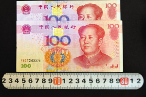 “加長(zhǎng)版”百元鈔票對(duì)比，明顯比其它鈔票長(zhǎng)一點(diǎn)，防偽線和字體的位置也不同。